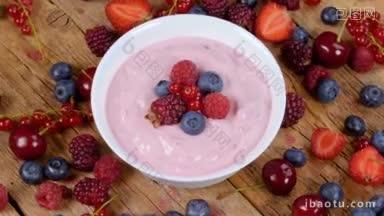 森林水果酸奶在碗旋转桌上充满新鲜水果的健康早餐饮食理念